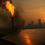 Gas flare and solar panels against a Nigerian city skyline at golden hour, representing Nigeria’s energy transition gamble.