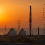 African natural gas facility with pipelines under sunset, reflecting the tension between Africa’s gas ambitions and global green energy commitments.